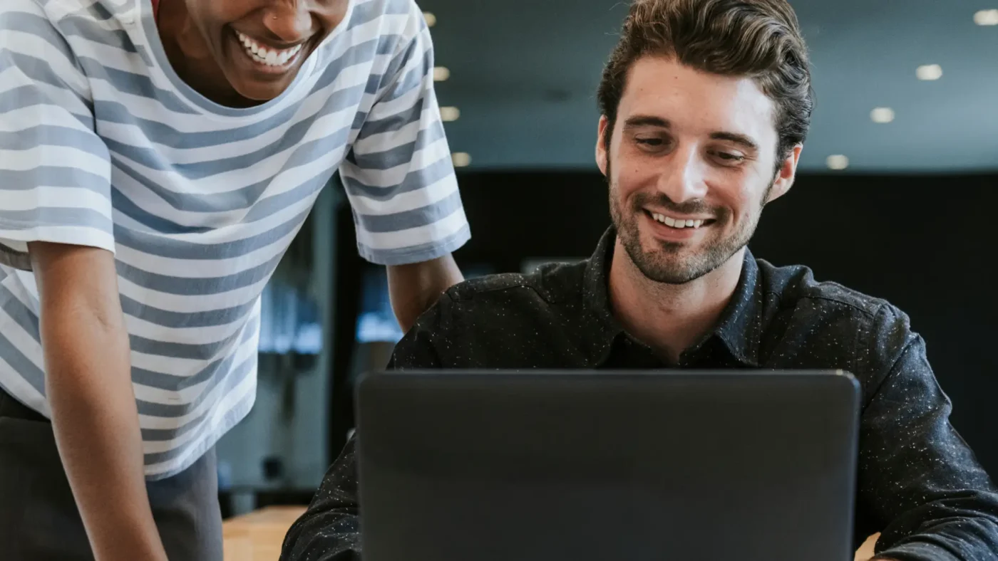 Colleagues discussing their work in front of a laptop