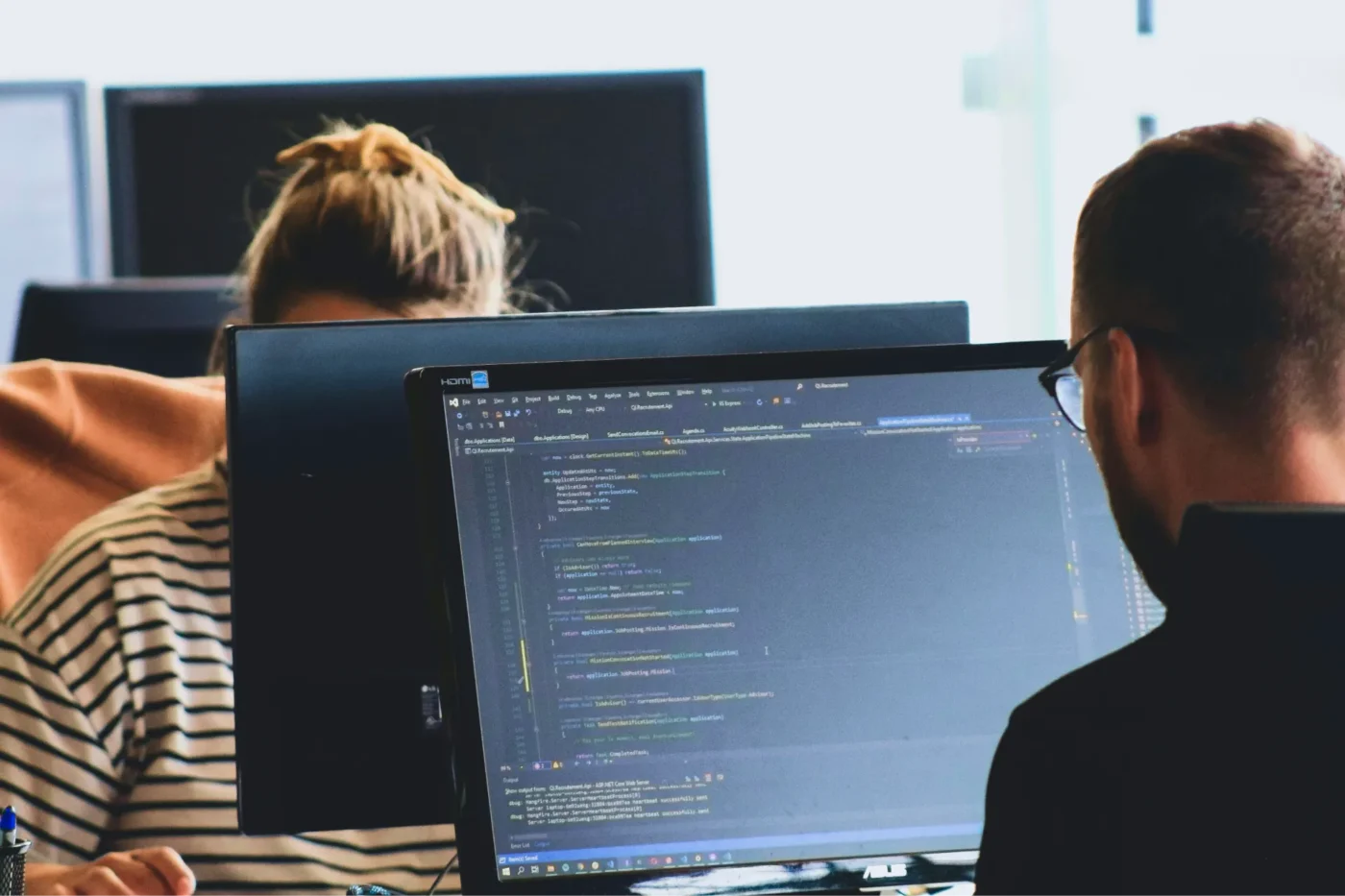 Two people coding on their computers